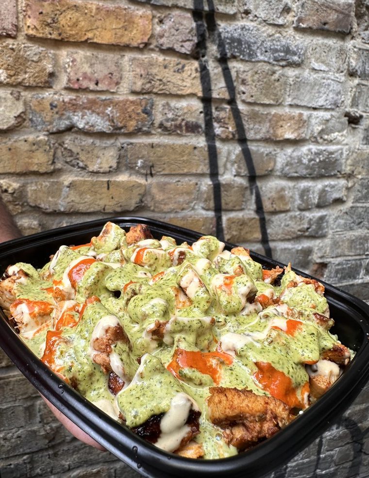 The first Peruvian Street Kitchen box, chicken and rice under green sauce.